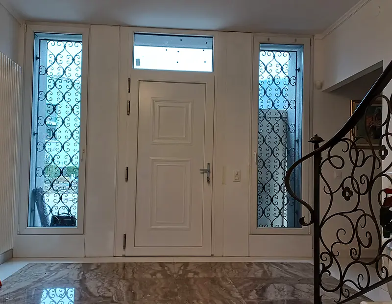 Ingresso bianco con sopraluce e laterali con grate decorative