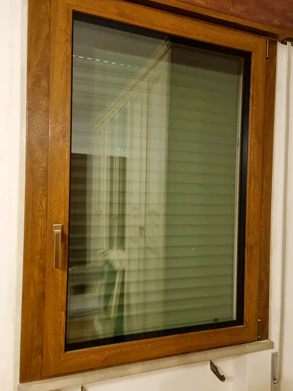 Dettaglio di finestra effetto legno con tenda interna